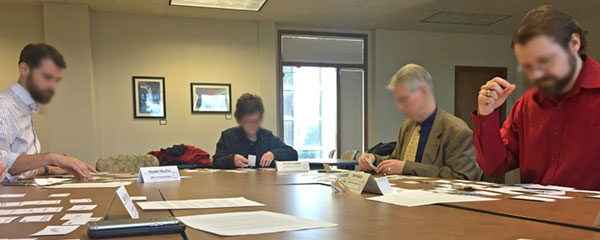 A group of participants finish a card sort test at an in-person focus group for the SAO website.